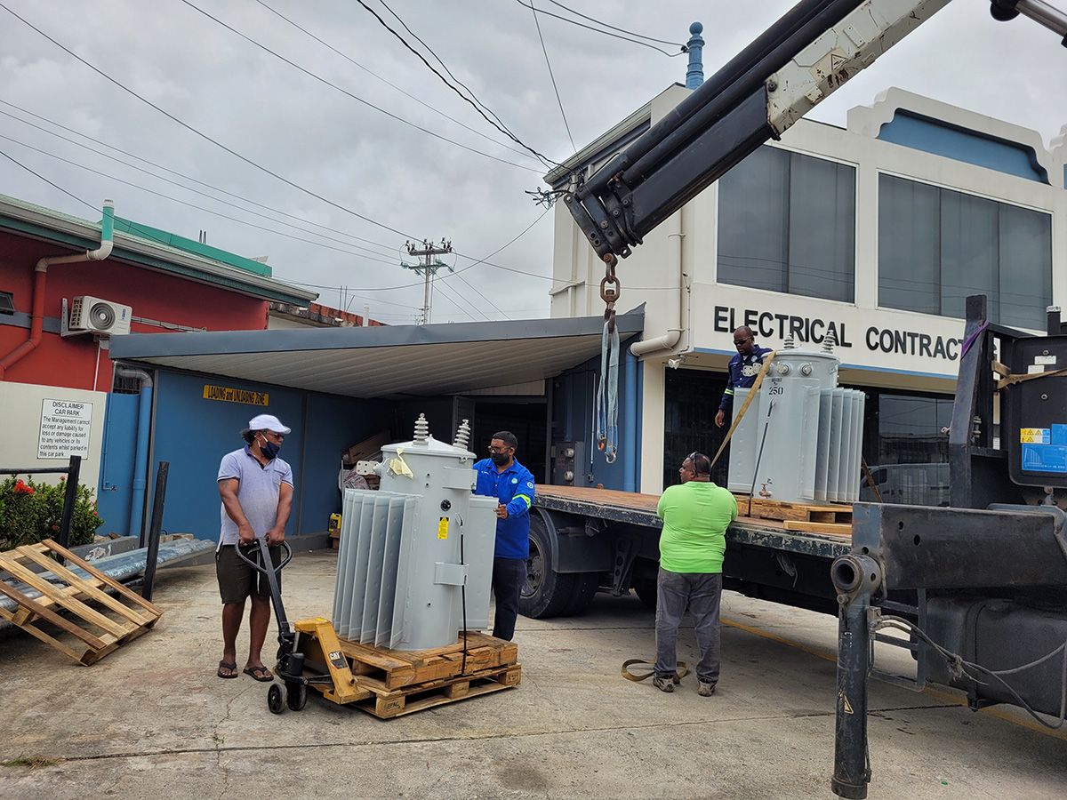 BELEC crane truck lifting transformers at the Arima yard