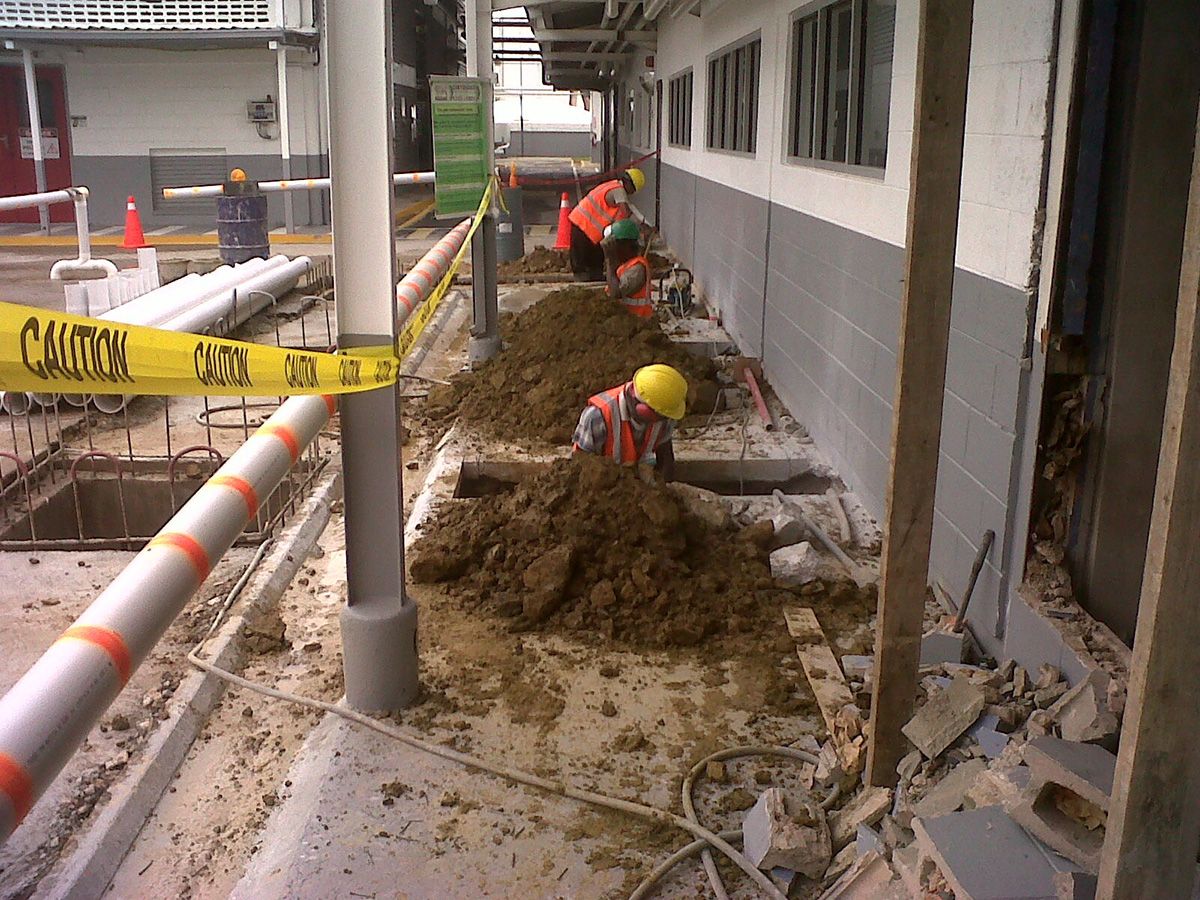 Crew trenching for new HV cable beside a school building