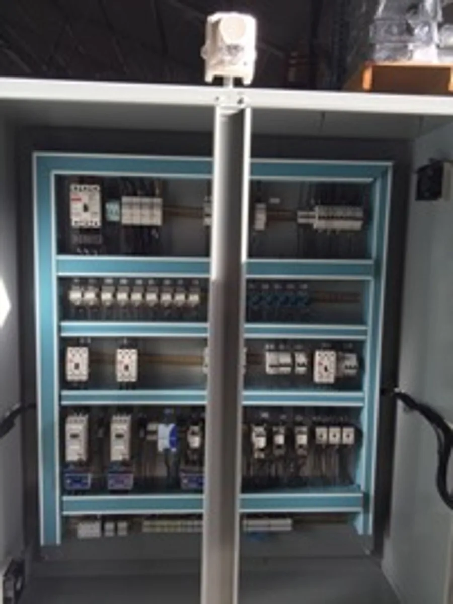 Backplate of an EMF-built control panel: DIN rail, breakers, contactors and dressed wiring