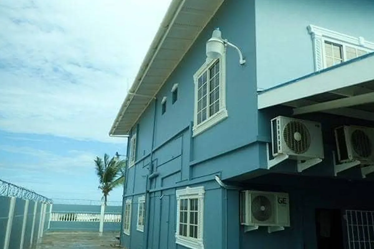 After: Same house repainted blue with white trim