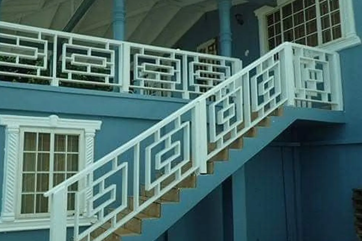 After: Same railings painted white against blue walls