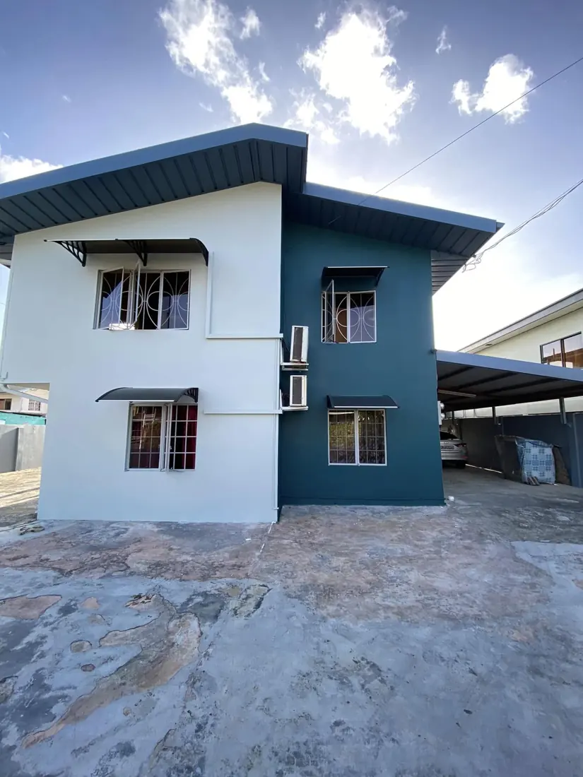 Two-storey house in white and teal