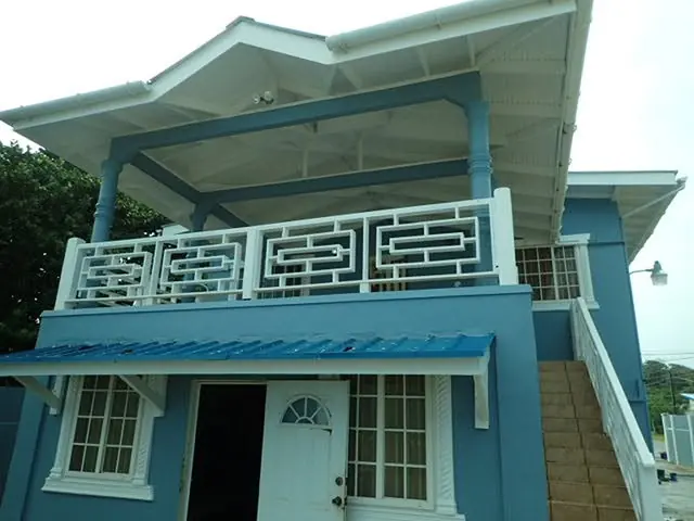 Teal house with white fretwork balcony
