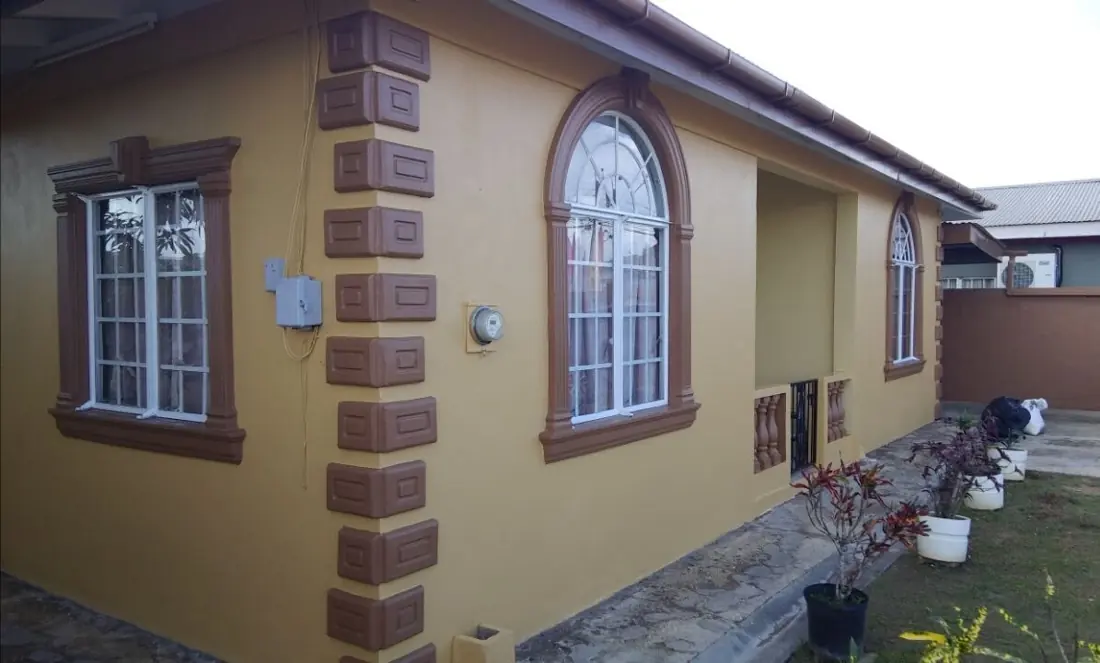 Finished exterior with brown quoins and arched window trim